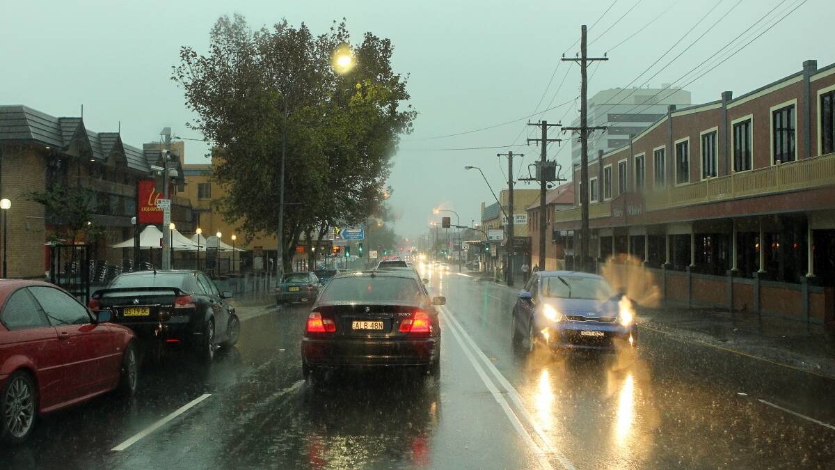 Rain pours down on Corrimal Street yesterday. The rain has led to flooding that has closed roads and train lines this morning. Picture: KIRK GILMOUR 