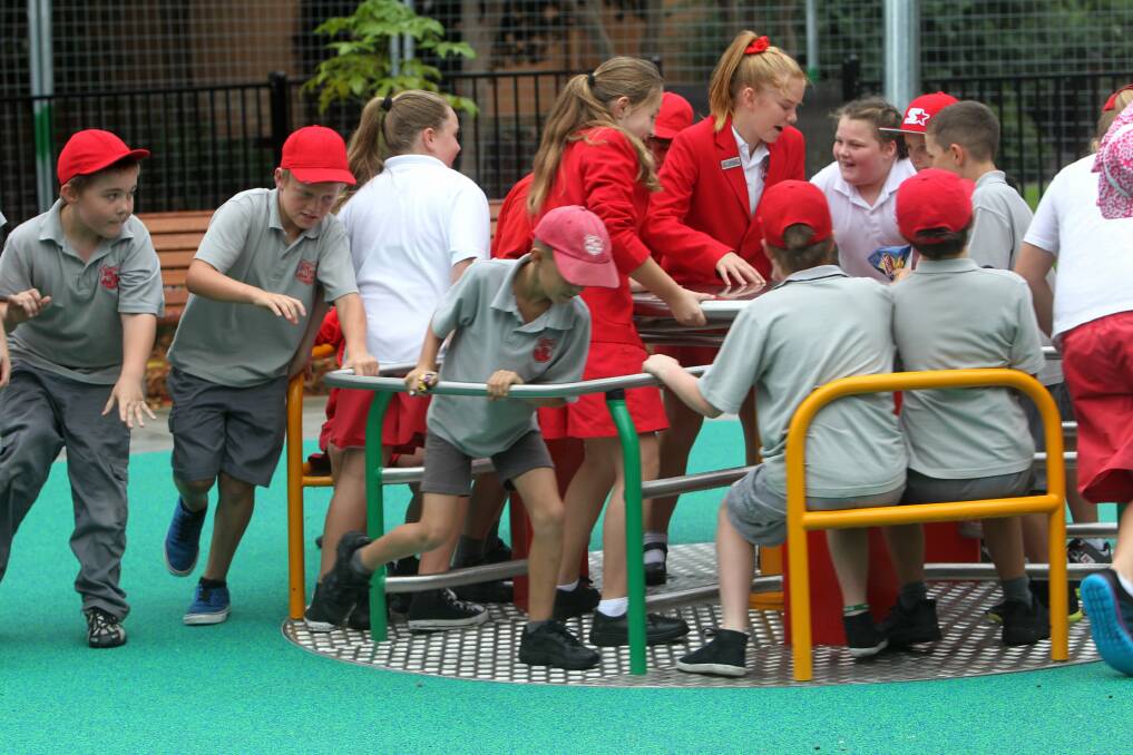 Corrimal Public School students try out the merry-go-round at Luke's Place. Picture: GREG TOTMAN