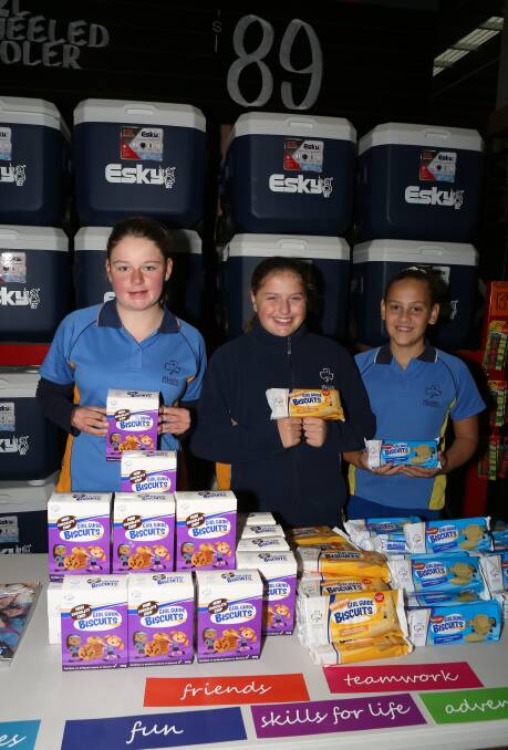Helping girls gain skills and confidence: Jessica Titmuss, Sophie Hunter and Stella Camargo selling Girl Guides biscuits at Bunnings Bellambi. Picture: Greg Ellis.
