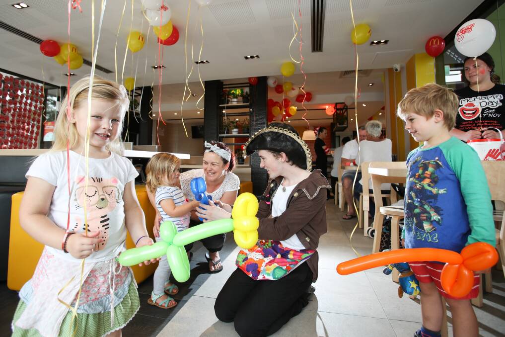 Fun day: Chris Rutter, of Dragon Fly Parties, ​with balloons for Taya, 4, Emmie, 2, Abby and Max Devitt, 5, at Warilla McDonald's. Pic: Adam McLean.



