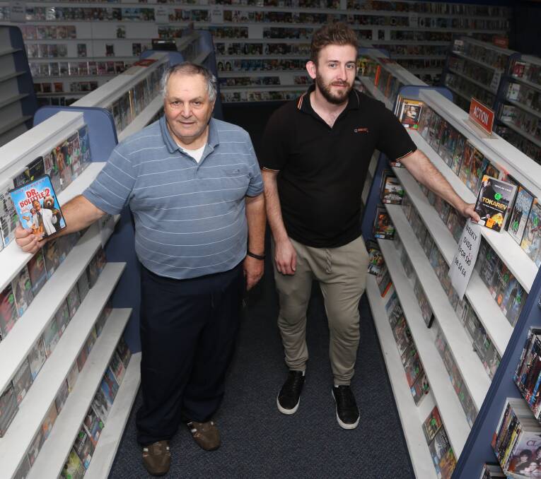 Farewell: In a sight once familiar in video stores across the nation Frank Floro and Goran Sterjovski stand in one of the aisles at Video Ezy Figtree before the store closes this Sunday to make way for a vet hospital. Picture: Greg Ellis.

