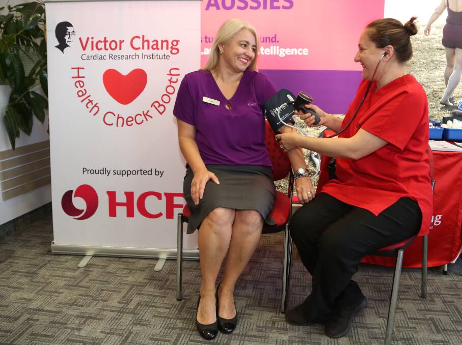 Check-ups: HCF customer service manager Daniela Mitrevski has her blood pressure taken by Siroun Woods as Victor Chang Cardiac Research Institute helps provide heart health checks at HCF Wollongong. Picture: Greg Ellis.
