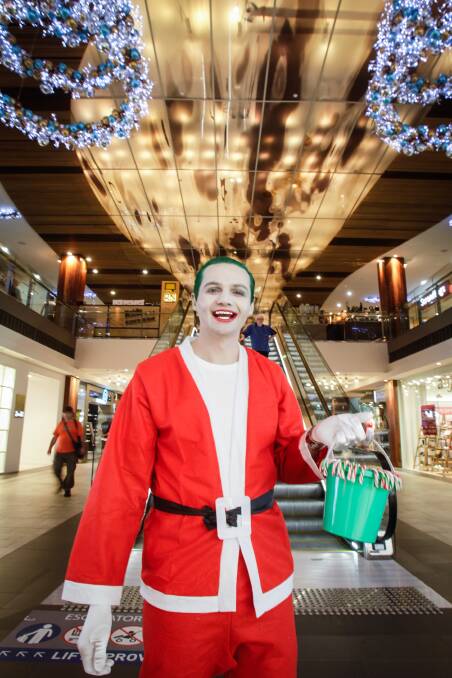 Boxing Day shopping no joke this Christmas: Ash Sargent dressed up as The Joker on Christmas Eve to hand out candy canes to shoppers. Picture: Georgia Matts
