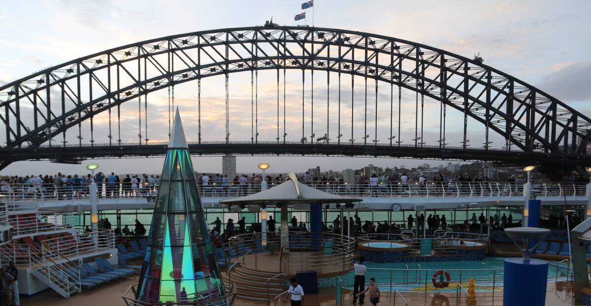 Capacity: Passengers line the pool deck of Voyager of the Seas to see the harbour bridge during recent departure from Sydney which could be one of the last. Picture: Greg Ellis.
