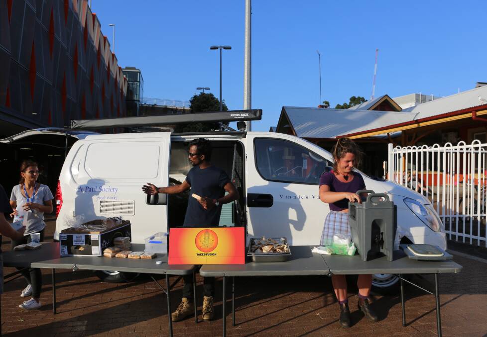 Lending a helping hand: Vinnies employee Sapphire Love with Goutham Arya Thota and one of his employees Lucia Hayes giving out food and beverages at Wollongong Railway Station on Monday night. Picture: Greg Ellis.



