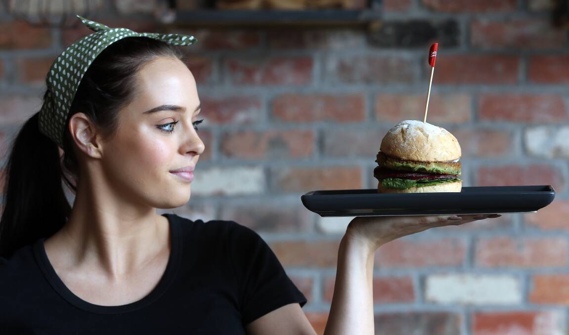 Grill'd Wollongong team member Alex Plummer with the new Hemp Burger now on the menu. But the only thing that is high are the Omega 3 levels. Picture: Robert Peet.





