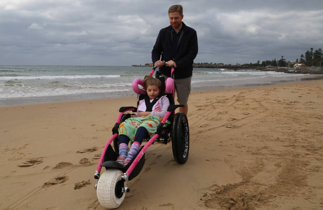 Mobility support: Bethany Loats on North Beach with dad Evan Loats in her new wheels  on Friday thanks to Kids Fund. Picture: Greg Ellis.




