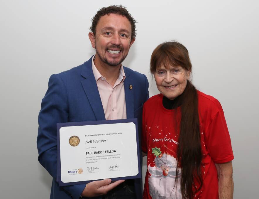 Prestigious award: Neil Webster with the Paul Harris Fellow certificate and pin presented to him by Rotary Club of Wollongong president Dot Hennessy. Pic: Greg Ellis.
