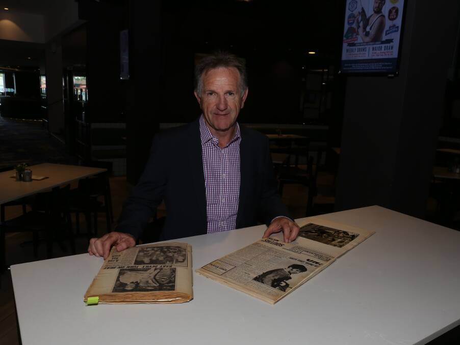 Reminiscing: Illawarra Rugby League great John Dorahy looking through some old newspaper clippings from his Red Devils playing days. Picture: Greg Ellis.

