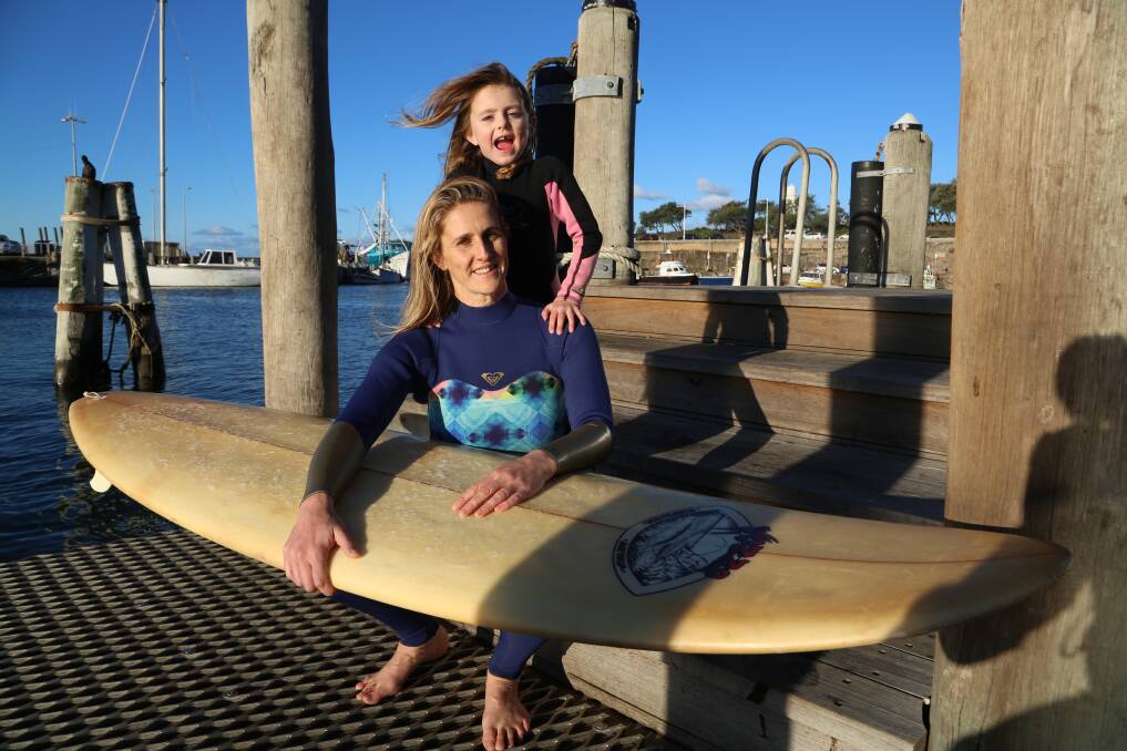 Making a difference: Catherine McMillan and her daughter Eliza heading back into the water on Tuesday to clean up more rubbish. Picture: Greg Ellis.

