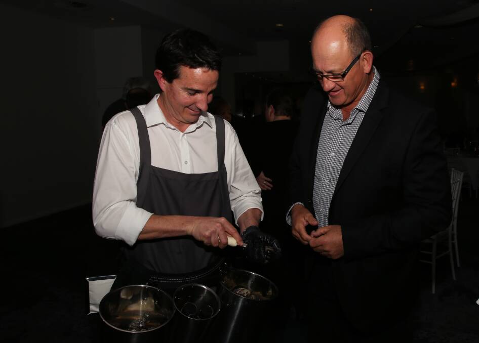 Oyster education: Grant Logue shucks an oyster for Mark Finlay at a Wollongong Golf Club. Picture: Greg Ellis. 