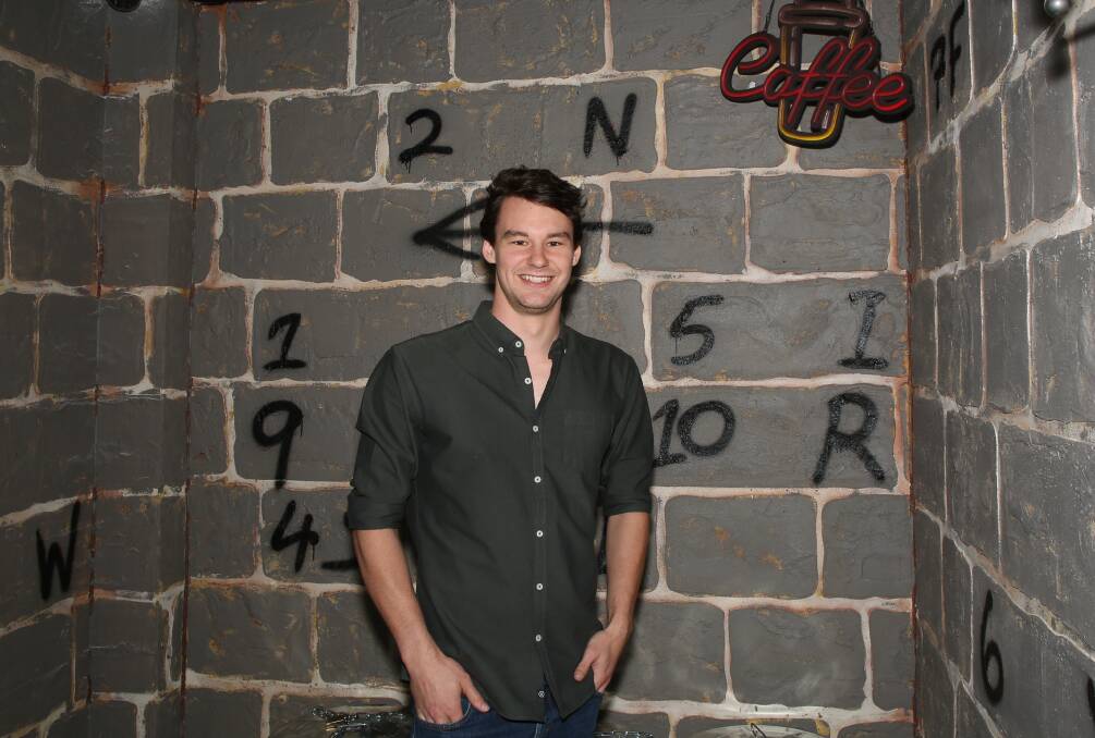 Sneak Peek: Mitchell Bloomfield is careful not to give too much away as he stands in front of some of the clues players will see as soon as they enter the new escape room. Picture: Greg Ellis. 
