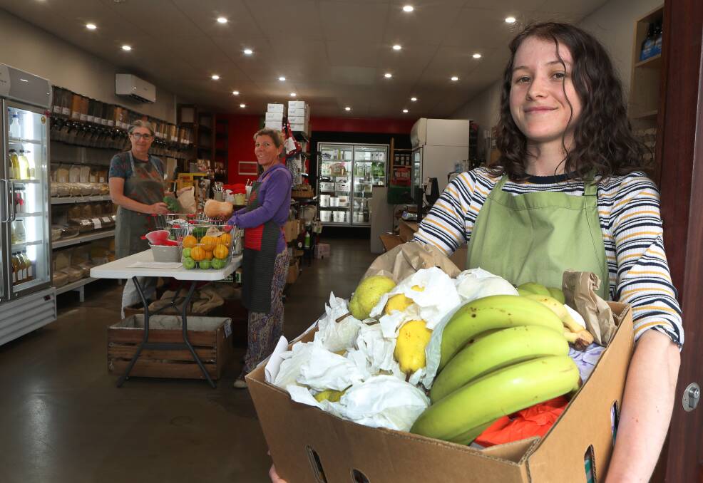 New service: Flame Tree Co-op volunteers Karla Sperling and Dominique Cook and retail assistant Freya Jarrett preparing online orders for customers to pick up in Thirroul. Picture: Robert Peet