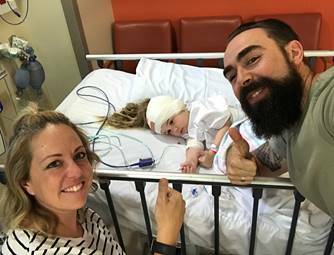 Fighting childhood cancer: Katie and Luke Rollinson with Harper after her cochlear implant surgery in 2017.
