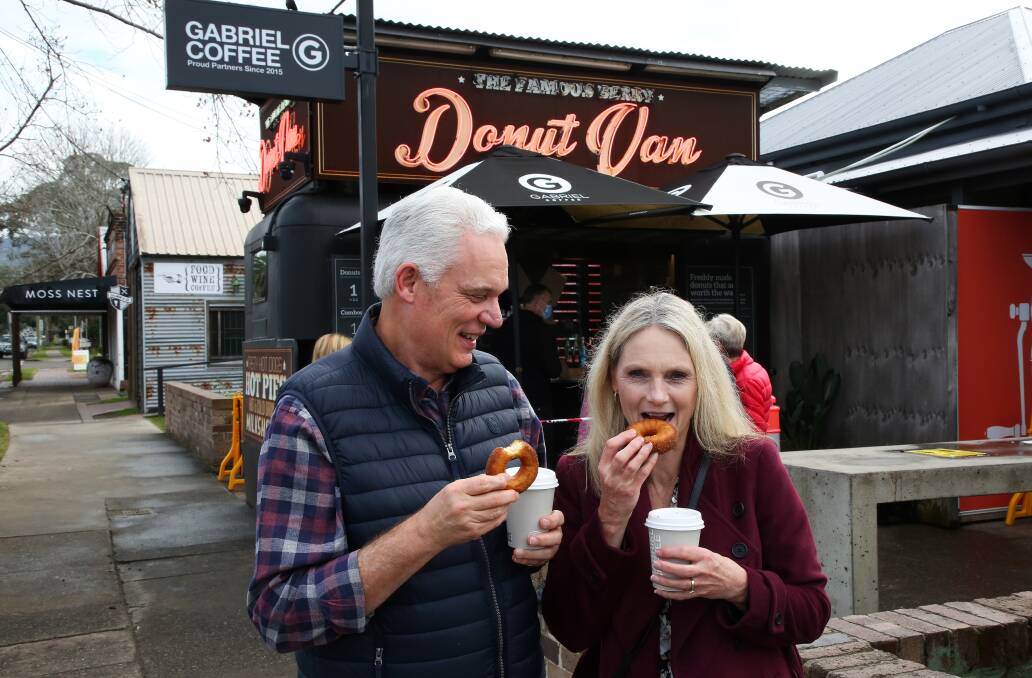 Worth the wait: After wearing masks at the counter Ann-Marie and Dallas Wilson enjoy their first Donut Van treat on the footpath.
