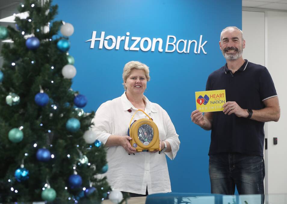 Defibrillator roll out: Horizon Bank's Kim Morris with the original yellow Wiggle Greg Page and the AED located at the Wollongong branch. Picture: Robert Peet.
