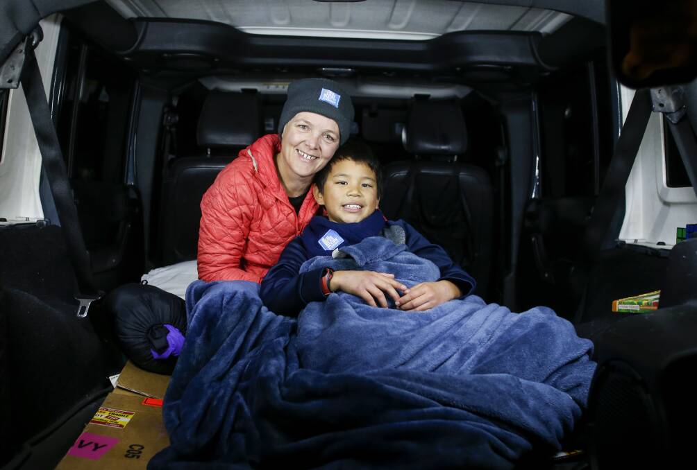 Helping the homeless: Cat Croghan doing the Vinnies CEO Sleepout with her nine year old son Jeng in her car parked out the front of her house on Thursday night. Picture: Anna Warr.

