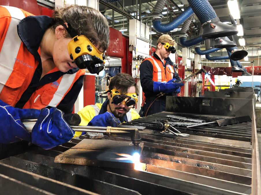 Head start: BlueScope electrical engineering cadet Victoria Wiffen with mechanical engineering cadets Daniel Quinten and Tyler Leggett learning to cut steel at TAFE Wollongong.

