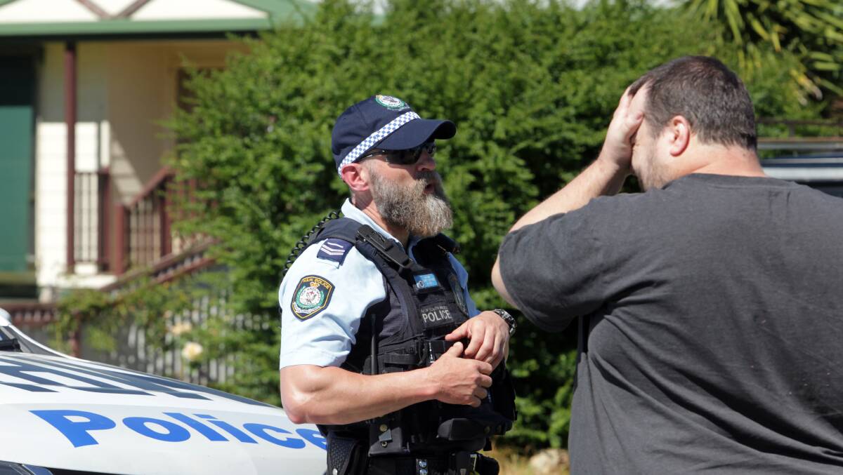  A man speaks to a police officer outside the Corowa home on Thursday. Photo: Blair Thomson