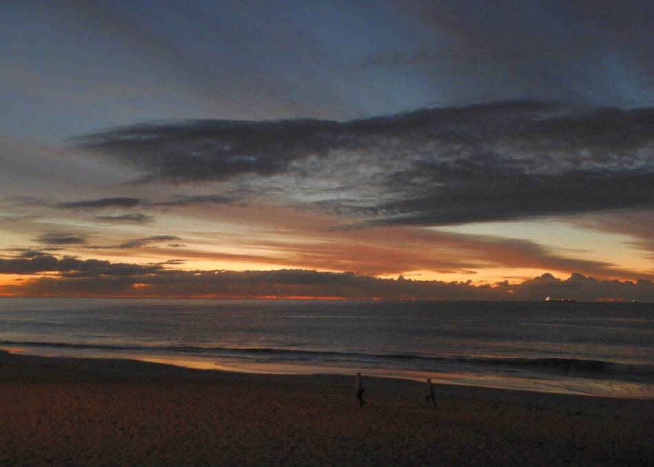 Early morning walkers under cloudy sky, taken at North Wollongong beach by Hans Haverkamp