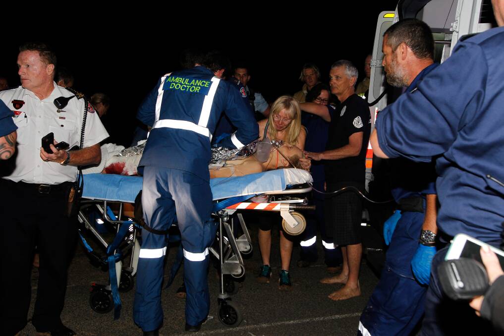 BOMBO ATTACK: Brett Connellan is treated by paramedics after being attacked by a shark at Bombo Beach in March, 2016. Picture: Sylvia Liber. 