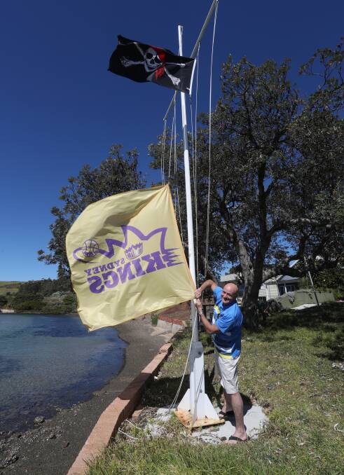 FLYING THE FLAG: Kings boss Paul raising his Sydney Kings flag in front of his Minnamurra property earlier this year. Picture: Robert Peet. 
