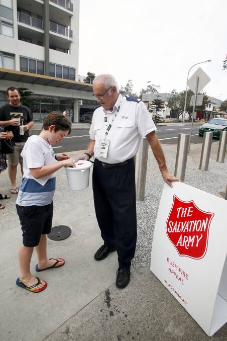 DIGGING DEEP: Hamish Lamplough makes a donation to Salvos volunteer Don Johnson on Saturday night. Picture: Anna Warr. 