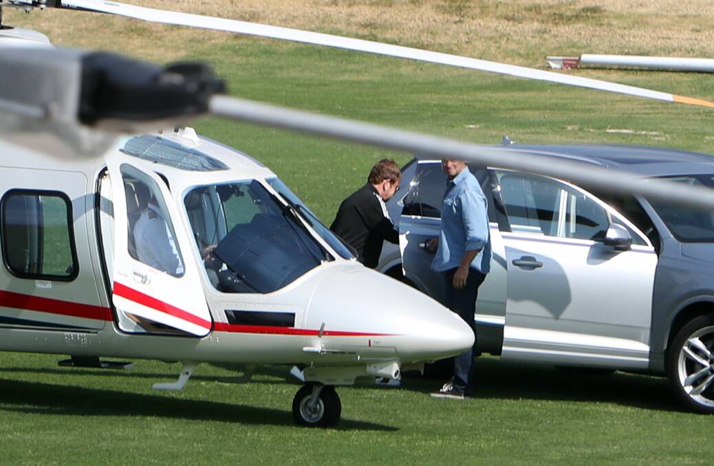 SIR ELTON'S RIDE IN THE SKY: Elton John getting out of the chopper and into a silver Audi on Sunday afternoon. Picture: Sylvia Liber.