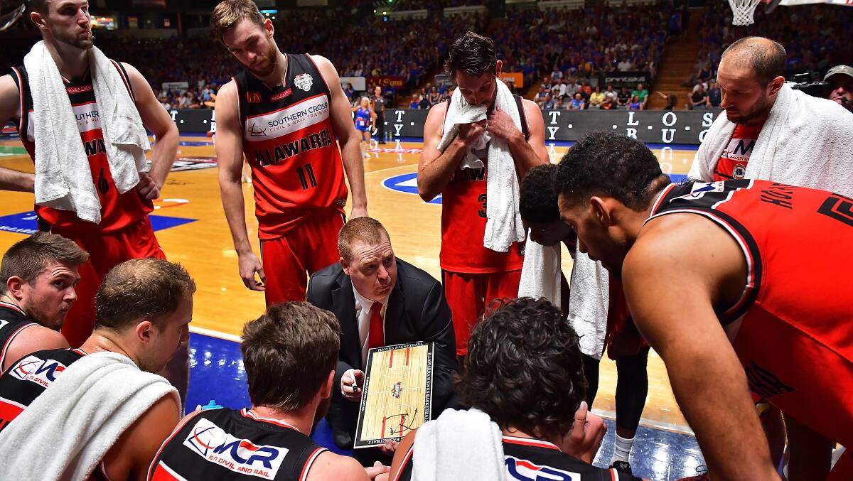 TALKING TACTICS: The Hawks tune into coach Rob Beveridge during Thursday night's encounter with the 36ers in Adelaide, which they lost. Pictures: Getty Images.