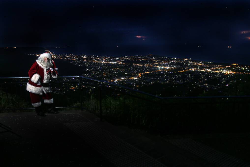 SPECIAL VISITOR: Santa posing atop of Mount Keira for a special image by Illawarra Mercury photographer Rob Peet in 2016. 