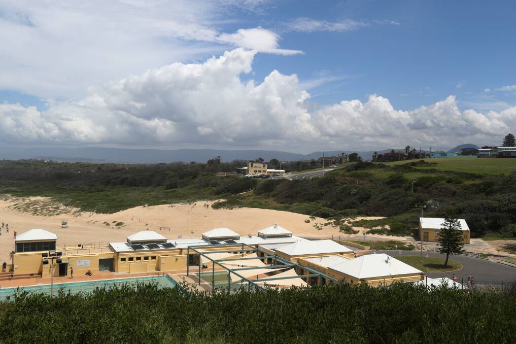 SANDY: A build-up of sand in front of the Port Kembla Surf Life Saving Club and near an equipment shed used by lifesavers (right of picture). Wollongong City Council has called for tenders to reshape the dunes. Picture: Robert Peet