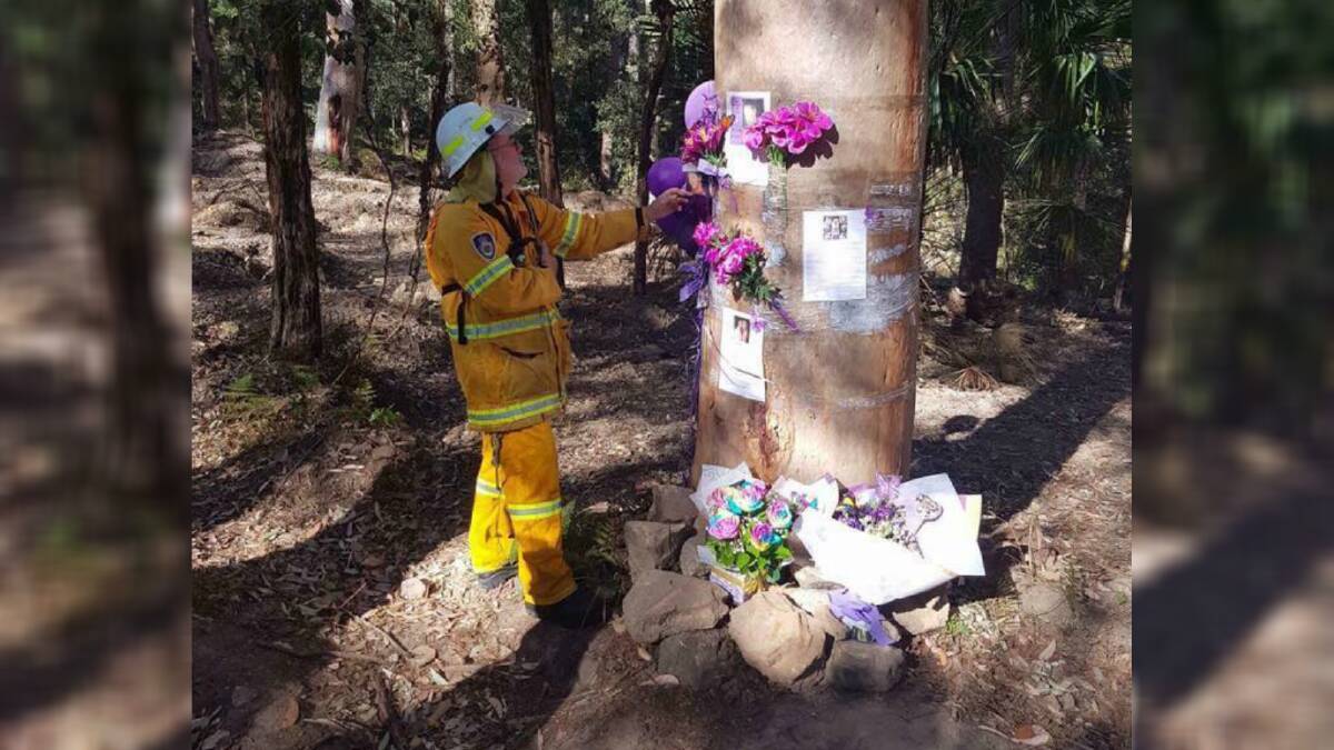A RFS volunteer stands beside Matthew Leveson's memorial tree, which escaped this week's fire in the Royal National Park near Waterfall unscathed. Picture: NSW Rural Fire Service Sutherland Shire 