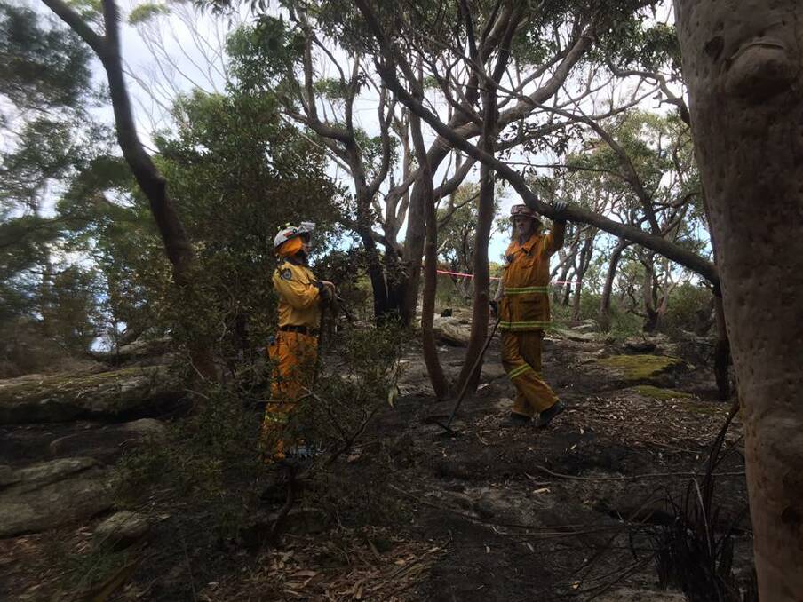 NSW Rural Fire Service volunteers battle difficult terrain near Otford. Crews had to access the fire on foot on Thursday, before a helicopter assisted in the fight on Friday. Picture: Facebook / Helensburgh Rural Fire Brigade
