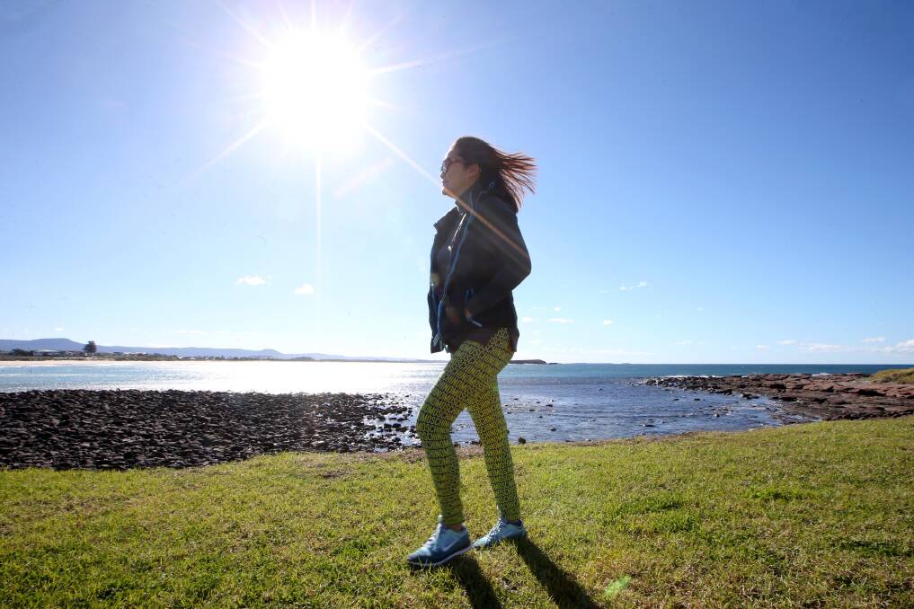 A rugged-up Michelle Maquiling enjoys the sun at Shellharbour on Thursday morning. Picture: Sylvia Liber