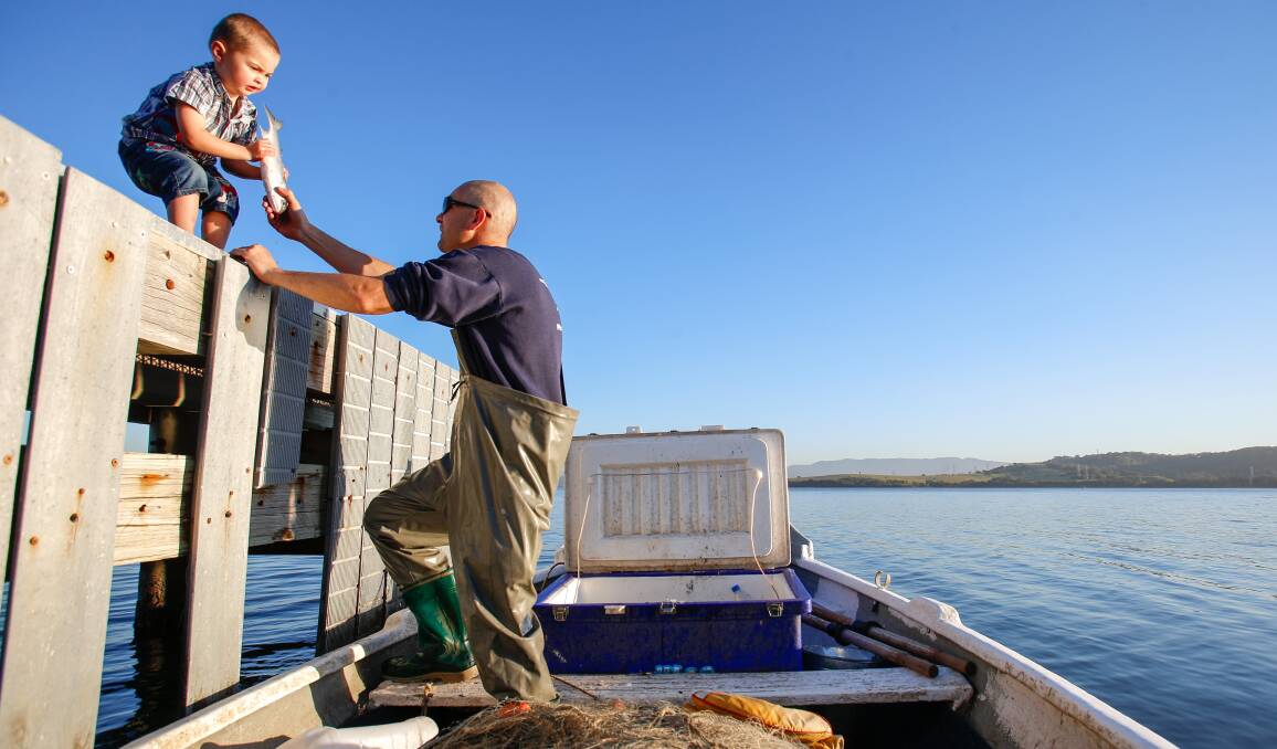 FIGHT: Fisherman Paul Heron with son Tyson, 3. Mr Heron has fished Lake Illawarra for 20 years, but fears for the future amid commercial fishing reforms. Picture: Adam McLean