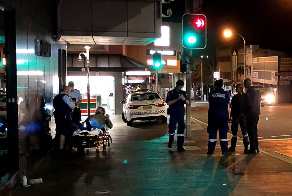 Police and paramedics on the scene of Tuesday night's mobility scooter crash at the top of Crown Street Mall. The scooter rider, a 53-year-old man, punched one of the paramedics who came to his aid. Picture: Andrew Pearson