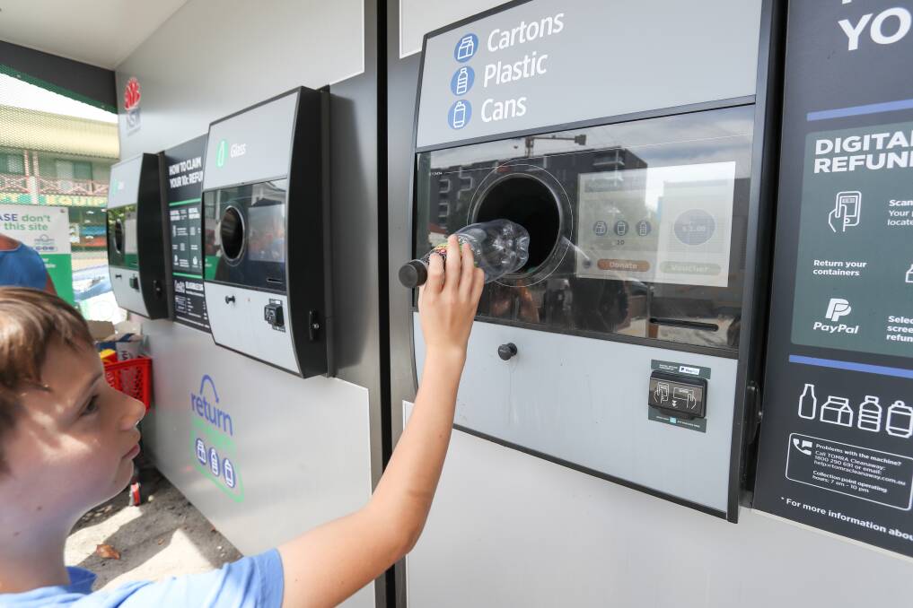 CASHING IN: Odin Heferen returns drink containers via the reverse vending machine at Wollongong's Woolworths store on Thursday morning. More than 13,000 containers were put in the machine on Boxing Day. Picture: Adam McLean