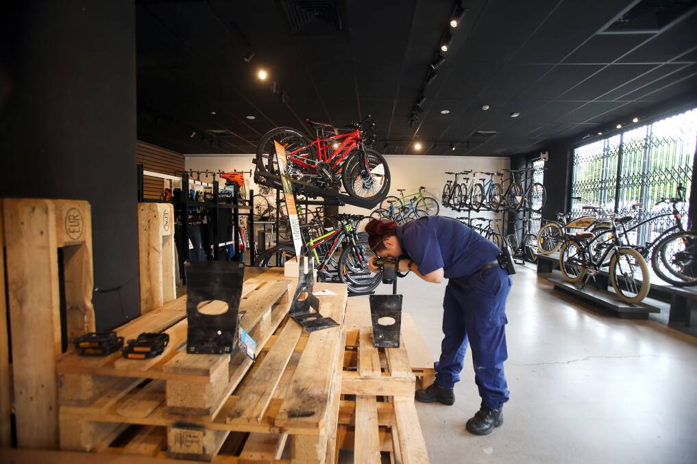 GONE: Police inspect the spot where four high-end mountain bikes were taken from the Shellharbour Simple Cycles store on Friday morning. Pictures: Sylvia Liber