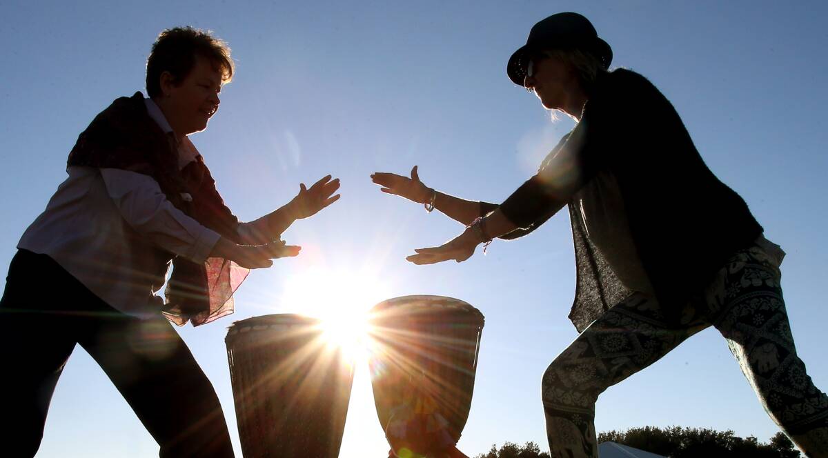 Jody Hezemans and Sally Oldroyd, of Djembe Jems, enjoy the early-morning sunshine as they fine-tune their drumming skills at Lake Illawarra on Friday. A hot, dry summer is on the way. Picture: Sylvia Liber