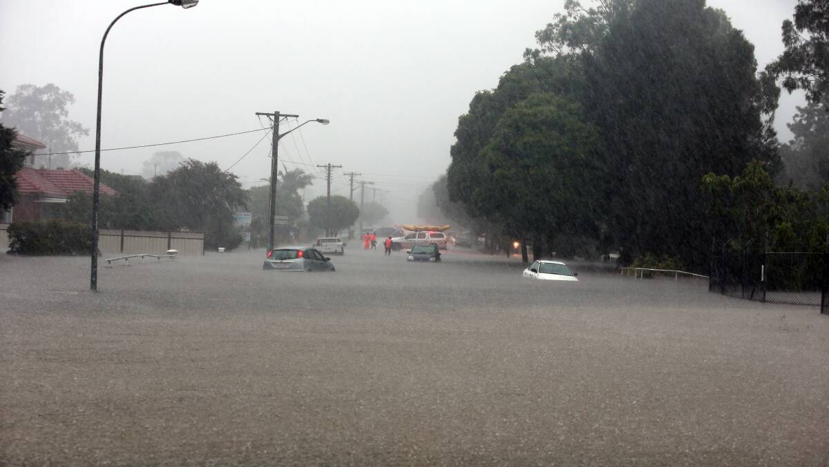 STUCK: Cars caught in floodwater on Station Road at Albion Park Rail on Thursday afternoon. SES crews responded to 34 flood rescues in three hours. Kembla Grange, Dapto and Albion Park were among hot spots. Picture: Robert Peet