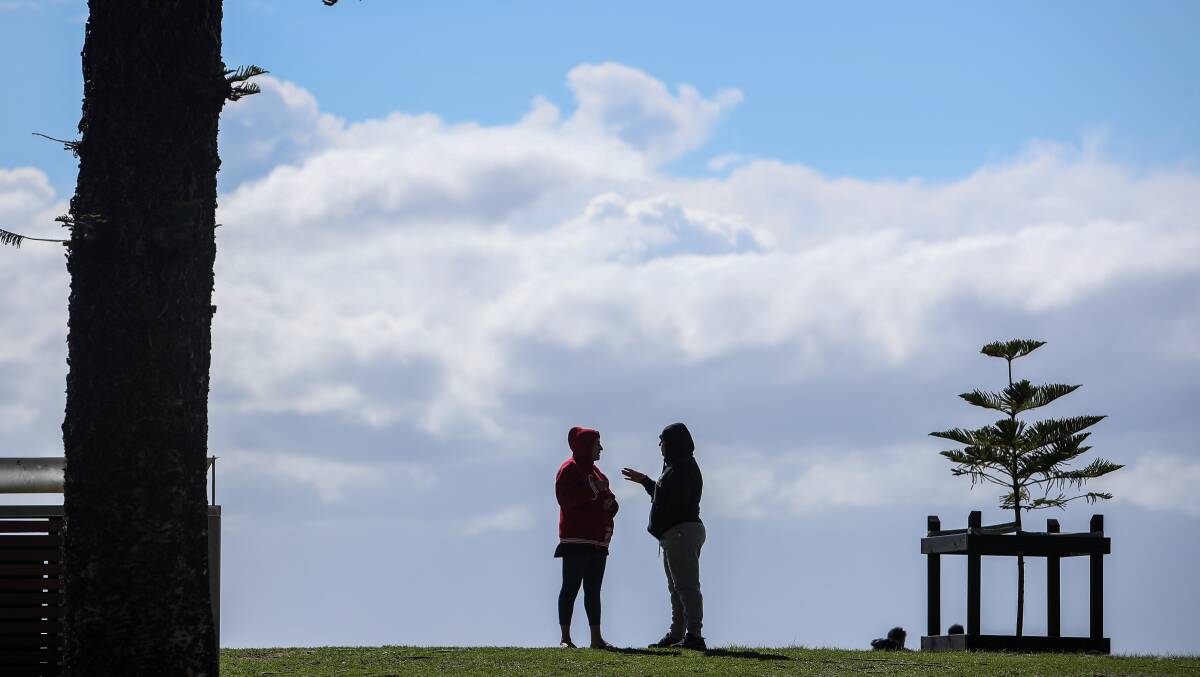 These people donned hoodies to shield themselves from the wind chill at North Wollongong beach on Sunday morning. Picture: Adam McLean