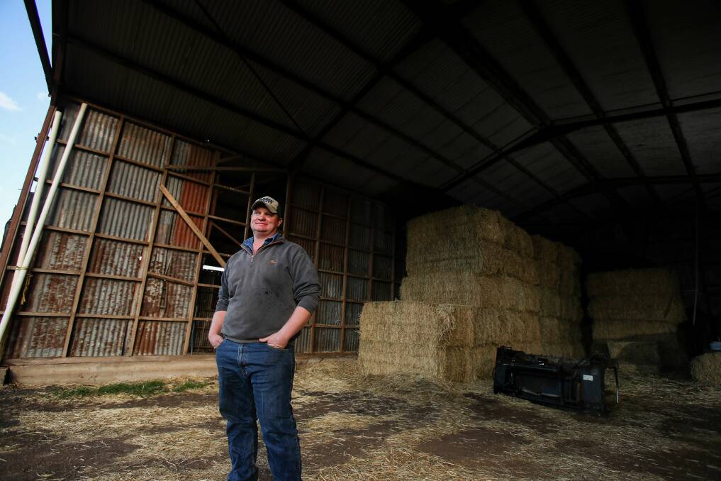 Tim Chittick on his family's dairy farm at Gerringong this week. The hay in the shed is from their second farm in central-west NSW. Picture: Adam McLean