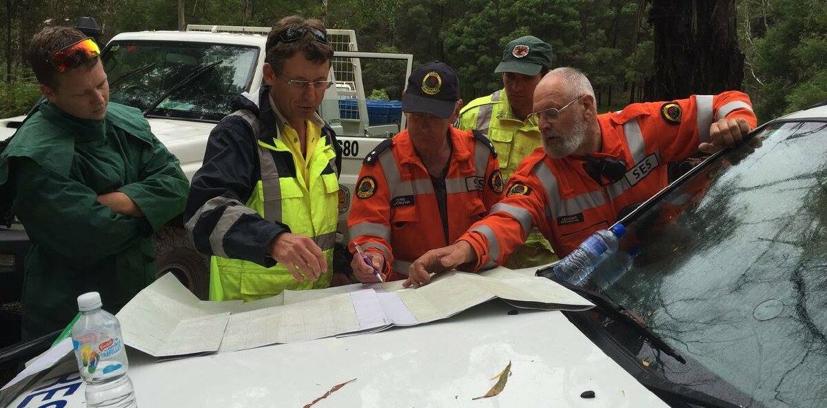 PLAN OF ATTACK: Rescue crews consult maps as they work to help campers stranded west of Moruya. Picture: NSW SES Illawarra South Coast