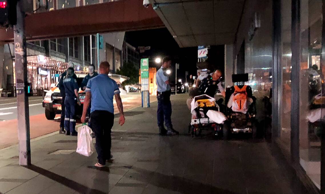 Police and paramedics on the scene of Tuesday night's mobility scooter crash at the top of Crown Street Mall. The scooter rider, a 53-year-old man, punched one of the paramedics who came to his aid. Picture: Andrew Pearson