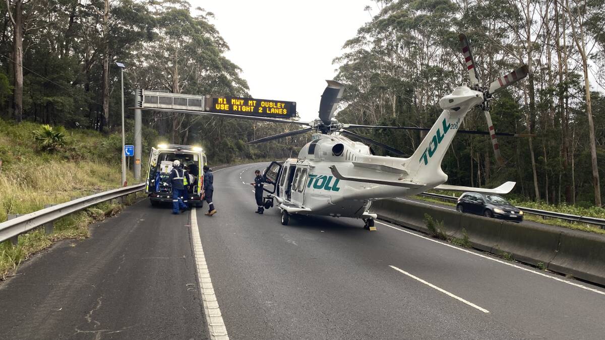 Emergency services assisting the injured truck driver on the M1 Princes Motorway at Bulli following a two-truck crash. Pictures supplied
