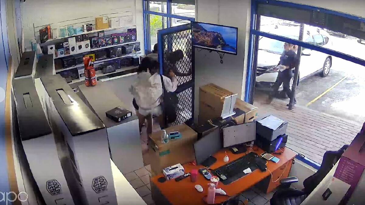 A still image from CCTV footage showing three females and a PCC Computers staff member (with arm up in the doorway) in the Dapto store on Monday, March 11. Picture supplied
