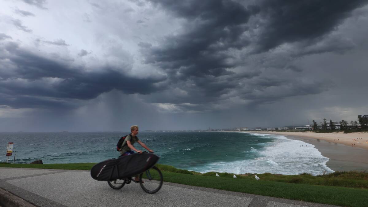 A person riding a bike under dark, grey clouds at Flagstaff Hill, Wollongong. File picture by Sylvia Liber