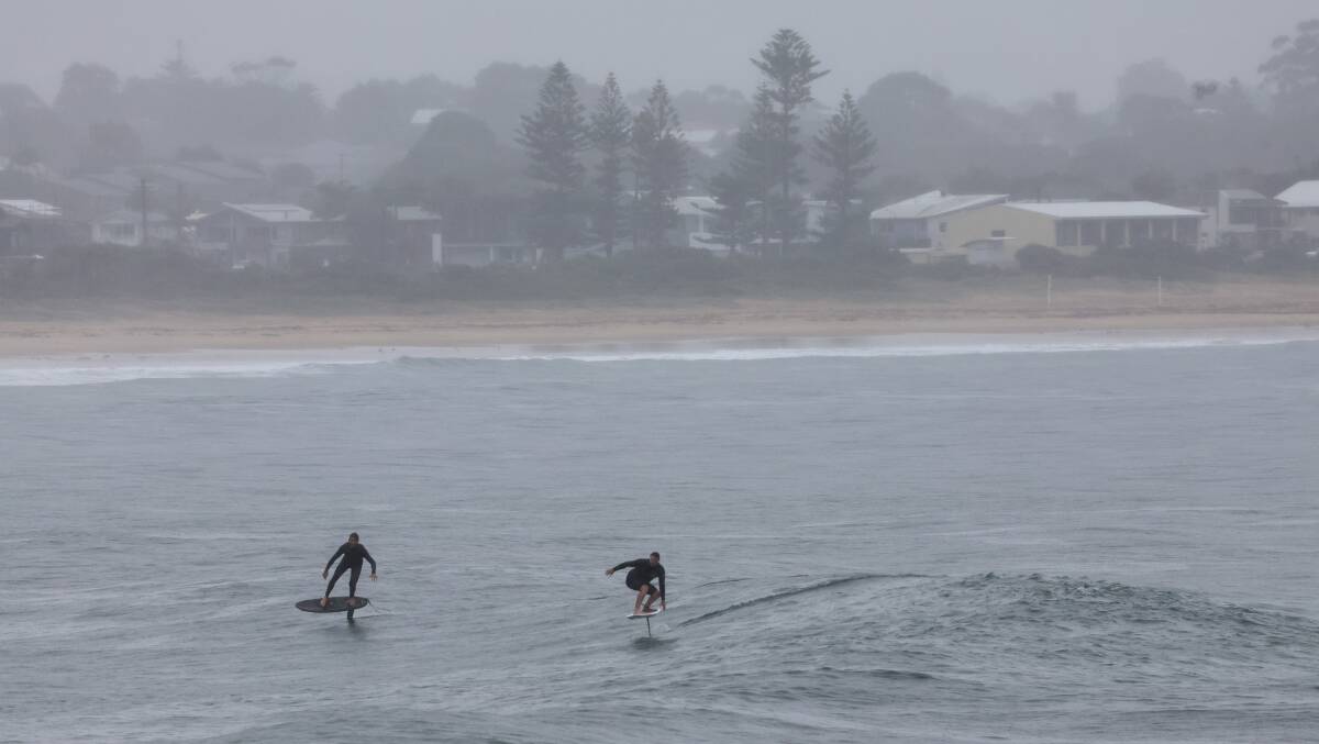 Surfing in the rain at Bellambi on May 6, 2024. Picture by Sylvia Liber