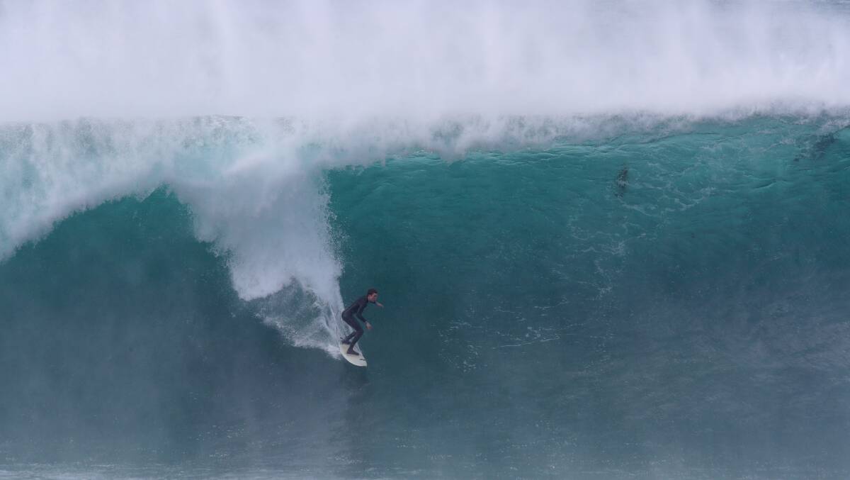 Surfers enjoying the huge 10-foot swell rolling into Shellharbour on Tuesday morning. Picture by Sylvia Liber
