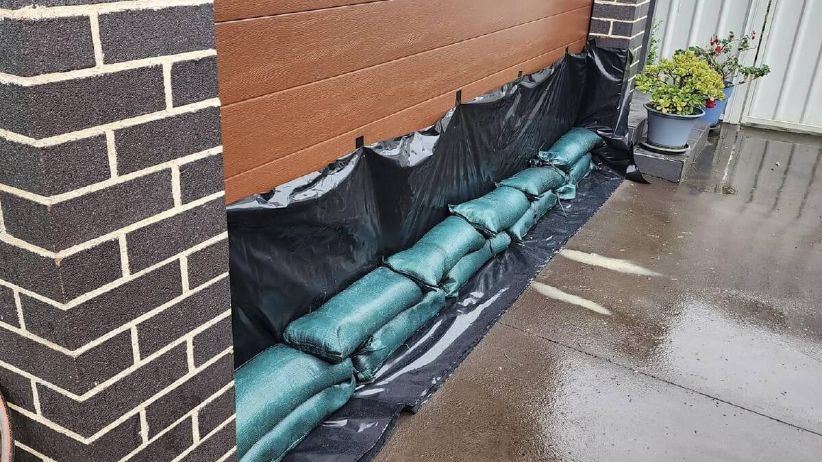 Sandbags lined up against a garage door. Picture by Shellharbour SES